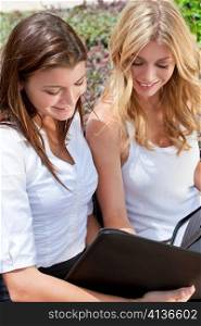 Two Young Businesswoman Outside Meeting Looking At Folder