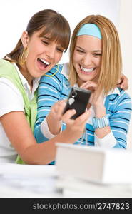 Two young cheerful woman with digital camera looking at pictures