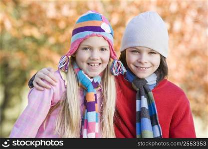 Two young children outdoors in park smiling (selective focus)