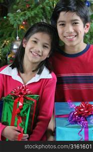Two young children with christmas presents