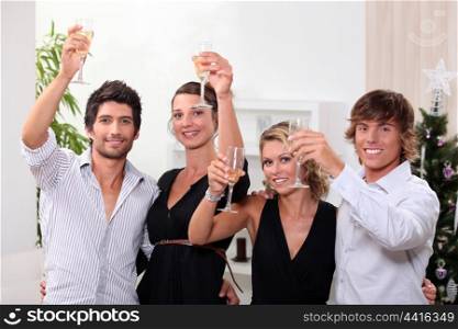 Two young couples drinking champagne at Christmas