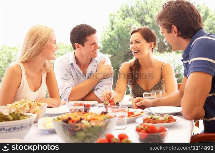 Two young couples eating outdoors