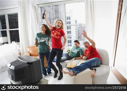 Two young couples enjoying beer and dancing in a living room