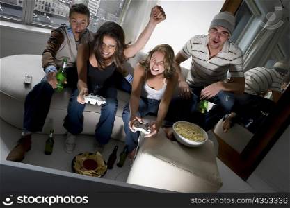 Two young couples playing video game and smiling