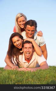 Two, young couples posing on a field