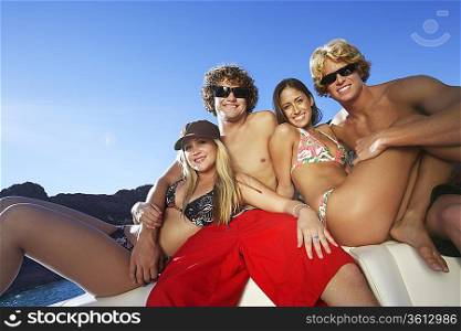 Two young couples relaxing on boat at lake portrait