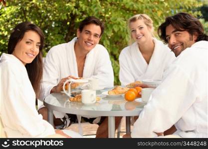 Two young couples sharing breakfast on the terrace