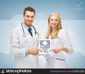 two young doctors pointing at tablet pc with medical app