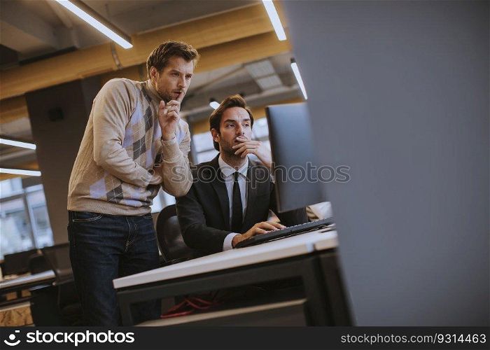 Two young employees working in the modern office