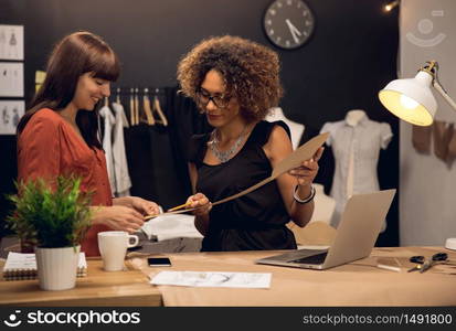 Two young entrepreneur women, and fashion designer working on her atelier