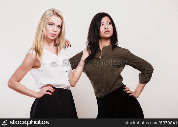 Two young fashion women caucasian and african studio portrait