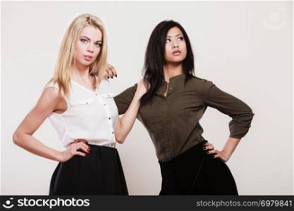 Two young fashion women caucasian and african studio portrait
