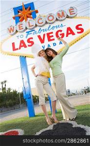 Two young female friends in front of Welcome to Las Vegas sign