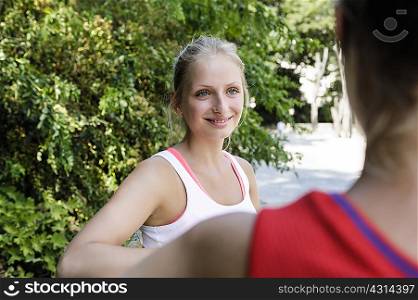 Two young female runners taking a break in park