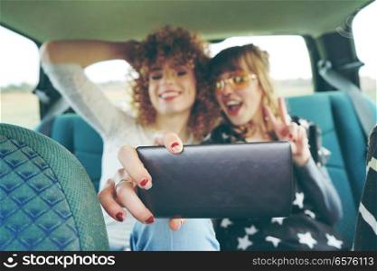 Two young friends taking a selfie in a road trip