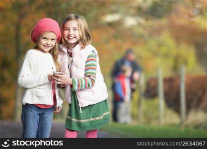 Two Young Girl Listening To MP3 Player Outdoors