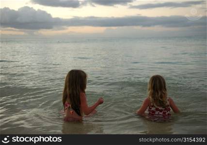 Two young girls (6-8) playing in water, Moorea, Tahiti, French Polynesia, South Pacific