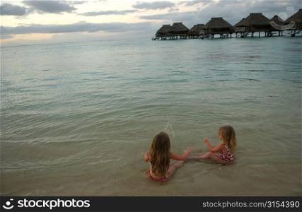 Two young girls( 6-8) playing on a beach, , Moorea, Tahiti, French Polynesia, South Pacific