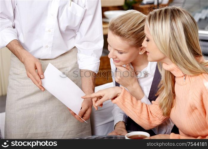 Two young girls choose in the dish menu