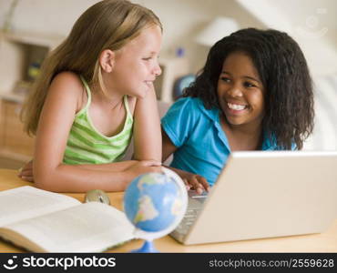 Two Young Girls Doing Their Homework On A Laptop