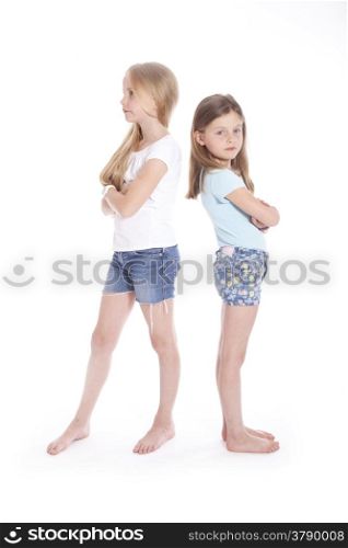 two young girls having a disagreement in studio with white background