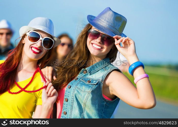 Two young girls. Image of two attractive young women in bright clothes having fun outdoors