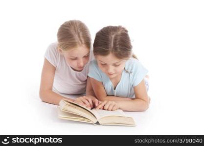 two young girls reading a book together in studio with white background