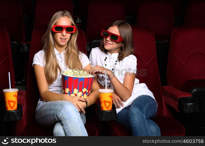 Two young girls watching movie in cinema