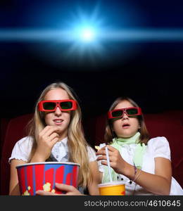 Two young girls watching movie in cinema