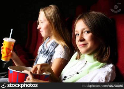 Two young girls watching movie in cinema