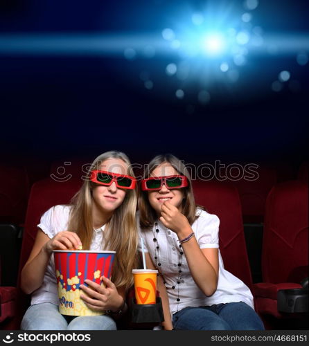 Two young girls watching movie in cinema