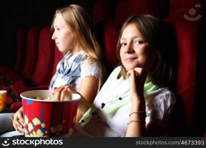 Two young girls watching movie in cinema