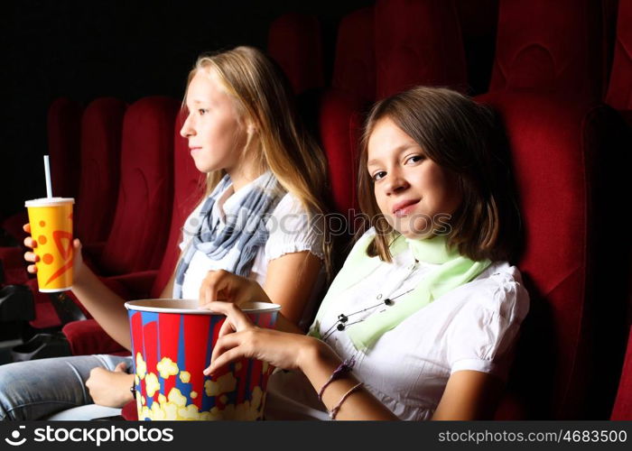 Two young girls watching movie in cinema