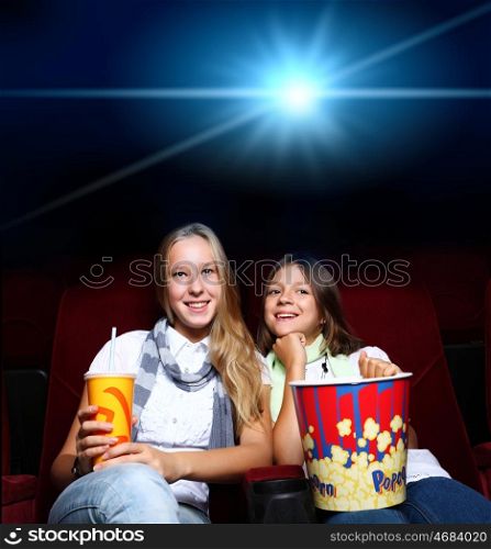 Two young girls watching movie in cinema
