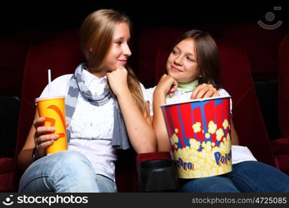 Two young girls watching movie in cinema