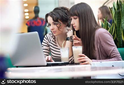 Two young girls watching something on notebook