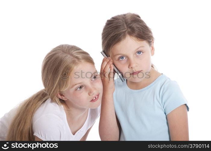 two young girls with mobile phone against white background