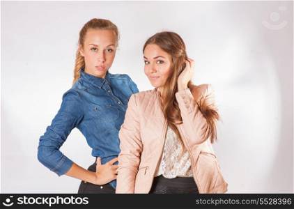 two young lady in studio posing in fashion manner