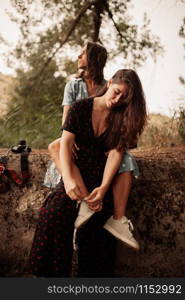 Two young lesbian women embraced on the field wearing dresses