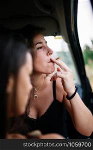 Two young lesbians smoking inside a car, lgbti concept