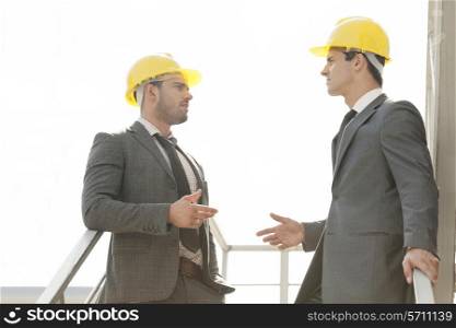 Two young male architect discussing on stairway