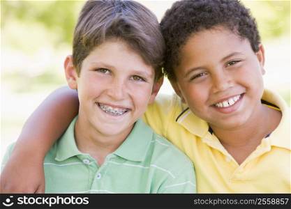 Two young male friends outdoors smiling
