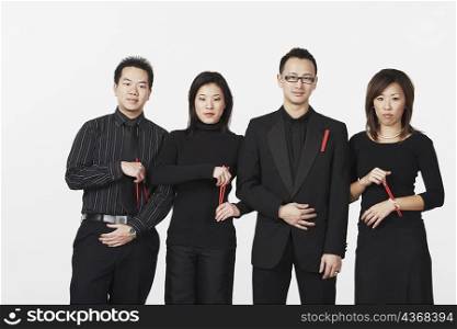 Two young men and two young women standing holding chopsticks