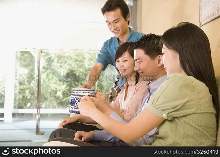 Two young men and two young women toasting with coffee cups