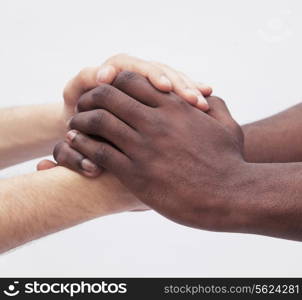 Two young men clasping each others hands, close-up, studio shot