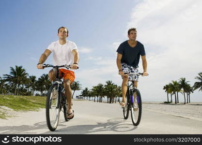 Two young men cycling on the road