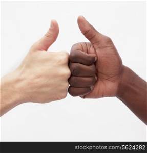 Two young men giving each other the thumbs up sign, close-up, studio shot