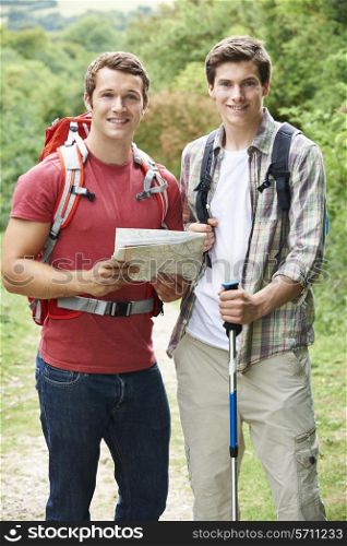 Two Young Men Hiking In Countryside Together