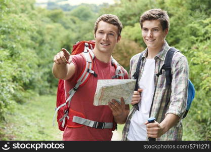 Two Young Men Hiking In Countryside Together