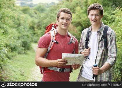 Two Young Men Hiking In Countryside Together
